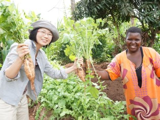 有機野菜を作るウガンダの生産者と坂ノ途中の宮下芙美子氏（左）