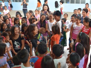 協力隊員（中央）と一緒に輪になって踊る子どもたち（2015年8月22日）