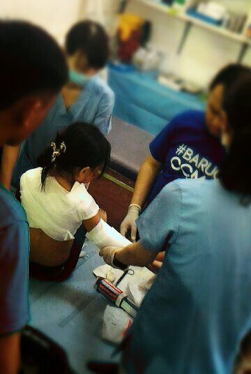 火傷を負った少女の処置を手伝うツアー参加者の大学生たち（フィリピン・セブ）