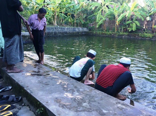 居住区で一番立派なモスクの中には、身を清めるための池がある。礼拝の前に手足を洗うロヒンギャの男性たち