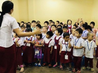 身体を動かしながら先生と歌の練習をする子供たち