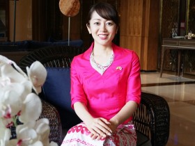 民族衣装をまとったすわじゅんこさん。胸元には日本とミャンマーの国旗が光る(ミャンマー・ヤンゴンで撮影)