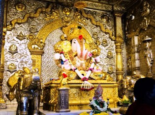 ダグダッシェス寺院の内部。黄金に輝くこのガネーシャ（写真の真ん中）はダグダッシェススタイルと呼ばれる（インド・プネー）