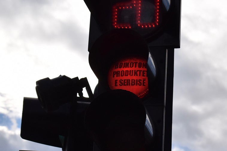「セルビア製品をボイコットしよう（bojkotoni produktet e serbisë）」とアルバニア語で書かれたシールが貼られた信号機（コソボ・プリシュティナで撮影）