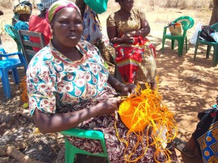 サイザル製のインテリアバスケットを編むケニア人女性。サイザルは「貧乏人の味方」と形容されるほど、乾燥に強く、どこでも育ち、また繊維がとれるため用途が多い有用な植物（写真提供：アンバーアワー）