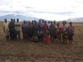 奪われた土地に立つモザンビークの農民ら。すでに大豆が植えられているという（写真提供：JVC）