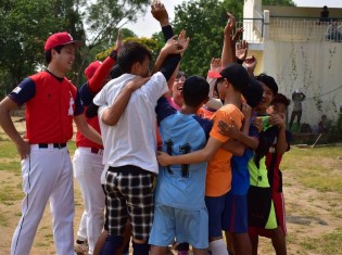 人生初めての野球の試合の前に円陣を組むドリームトレインの子どもたちと、それを見守るサムライズの日本人選手たち（ヤンゴンのチャイカサン球場で撮影）
