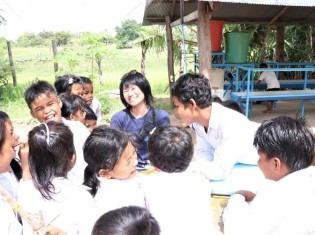 カンボジア・シェムリアップ州にある「プレイキションはちどり小学校」で子どもたちと本を読む宮手恵さん（中央）