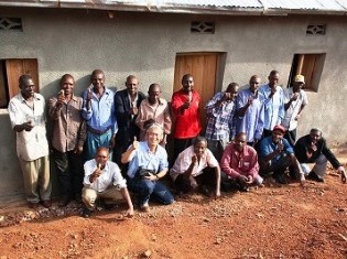 ルワンダ大虐殺の被害者の女性の家を建てた元受刑者と佐々木教授（前列左から2人目）。「佐々木さんを支援する会」提供