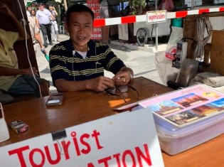 タイサッカーを熱く語るサマーイ・ソンガートさん。バンコク中心部に近いプラトゥナム市場の案内所で働く