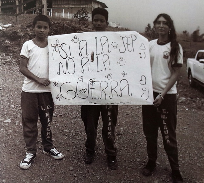 「和平合意を歓迎する！戦争は望まない！」と書かれたポスターを手にした学生たちを撮った一枚（プロジェクト・フォトボスから）
