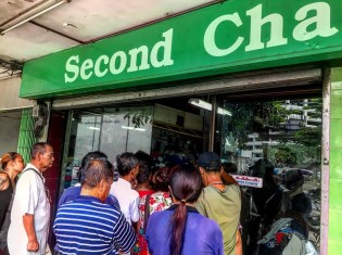 リサイクルショップが開店した瞬間。安くても良いものを手に入れよう、とスラムの住民が一気に押し寄せる（バンコクのクロントイ・スラム）