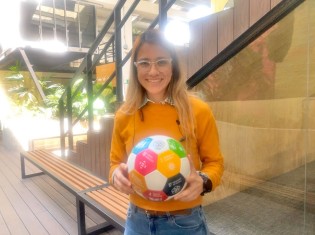 SDGsサッカーワールドカップ」（GGW杯）で使うサッカーボールをもつインパクト・ハブ・メデジンのスタッフ、ジュリアナ・デビラさん。8月のGGW杯に向け約1年かけて準備に取り組む（コロンビア・メデジンで撮影）