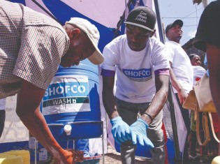 ケニア・ナイロビのスラムの住民に手洗いの仕方を教えるSHOFCOのメンバー
