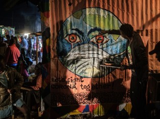 ケニアのアーティスト、グランドサンさんがナイロビのキベラ地区で描いたグラフィティ。地球がマスクを被っている。新型コロナウイルス感染症の予防意識を高めることが目的だ。2020年3月23日に撮影（Yasuyoshi CHIBA / AFP）