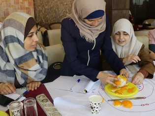 パレスチナの理科教師に「パレスチナ子どものキャンペーン」が実験のやり方を教えているところ。身近なオレンジを使って地球のプレート構造を理解する
