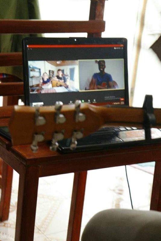 ギターのオンラインレッスンをしているところ。講師は指の動きをカメラに映して弾き方を指導する。世界9カ国から生徒がレッスンを受ける