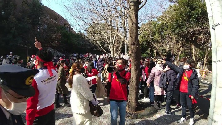 「We♡Myanmar」の白いベストを着た男性、赤いNLDのTシャツを着たボランティアスタッフたち。拡声器などを使ってデモの参加者を車道にはみ出ないよう誘導する