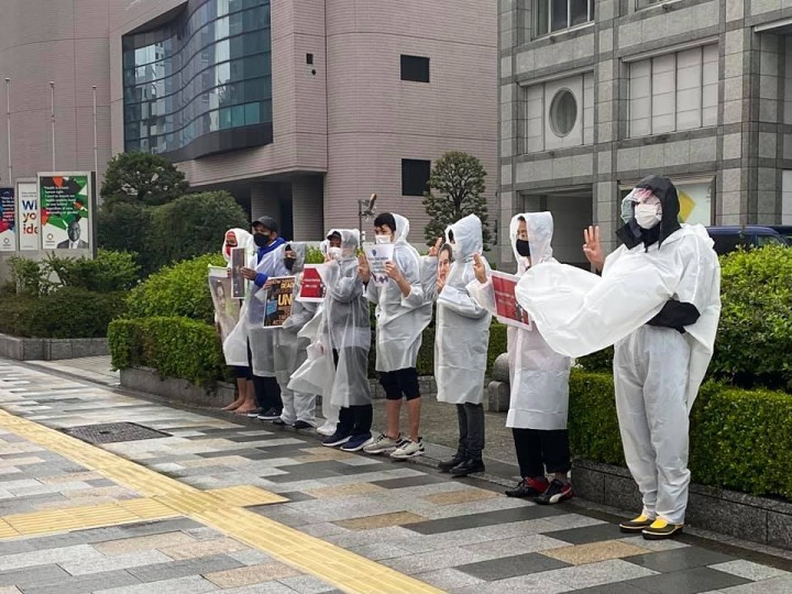 ミャンマーの現状を知ってもらうために雨の中、通行人に声かけをするハンガーストライキの参加者たち（東京・渋谷の国連大学前）