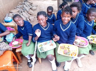 5月24日の「アフリカの日」に、コーナーストーン・オブ・ホープが出した特別な給食。ザンビア各地の伝統的なおかずがずらり。子どもに人気だったのは、ヤギ肉のシチュー、魚のトマト煮込み、チカンダ（ピーナツを原料とするソーセージ）。5月初旬にもらった制服を着て、みんなで楽しく「いただきます！」
