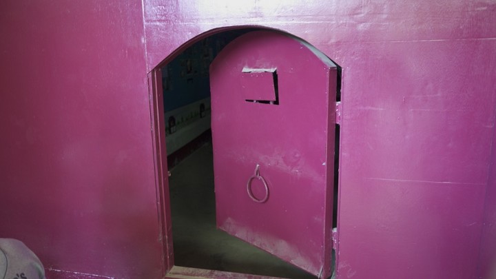 ピンクのペンキが塗られた展示スペースの小さな入り口。インセイン刑務所の入口を模したものだ