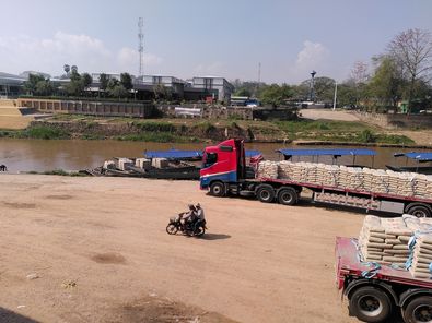 トラックからボートに荷物を運んでいるところ。モエイ川沿いの一部では今も物資が取引されている（メーソット）
