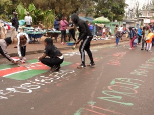 道路を埋め尽くすメッセージとケニアの国旗（ケニア・ナイロビのキベラ）