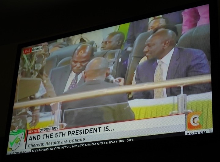 独立選挙区割り委員会（IEBC）の チェブカティ委員長（左）と談笑する新大統領に選ばれたルト氏（右）