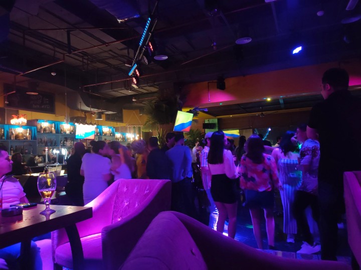 学校近くのクラブで先週開かれた、コロンビア人ばかりが集まるダンスパーティーのようす。テレビ画面にはコロンビア国旗が映し出されている。コロンビア人の女子大生ルイサさんに連れて行ってもらった