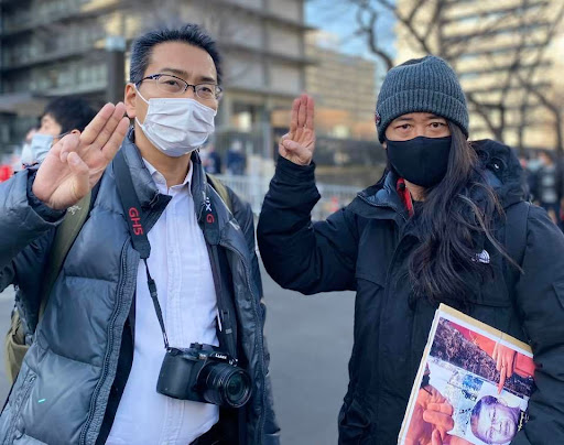 ジャーナリストの北角裕樹さんと三本指を掲げる保芦さん（都内で撮影）。ヤンゴンで当時活動中だった北角さんは2021年4月にミャンマー国軍に拘束されたが1カ月後に解放、日本へ帰国した（保芦さん提供）
