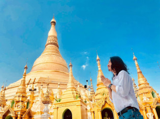 ヤンゴンにあるシュエダゴンパゴダの前でお祈りする保芦さん。保芦さんは2011年に初めてミャンマーを訪問。2016年に移住した（保芦さん提供）