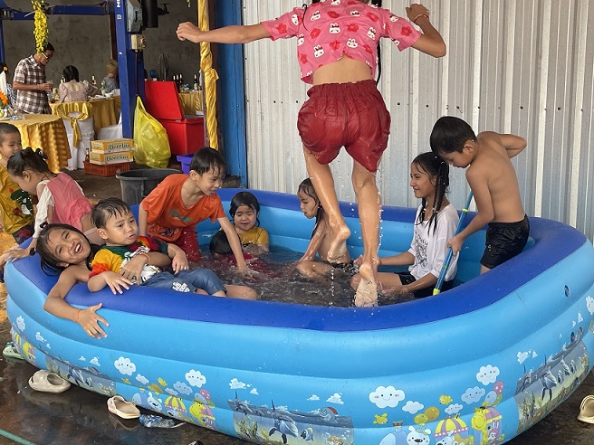ビニール製の大型プールで子どもたちは水浴びしたり、水鉄砲で水をかけあったりして大はしゃぎ