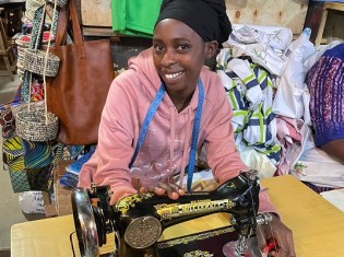 ルワンダの首都キガリ市にあるキミロンコ市場で服作りをしているオダ・ムヒムンドゥさん（22）。手にしているミシン1つで新天地に生きる