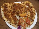 クルド風ピザの「ラフマジュン」。薄めの生地にひき肉やトマトを混ぜた具を乗せて焼き上げる。クルド人の大半が暮らす中東では定番の料理。フェスの当日は、在日クルド人が手作りしたラフマジュンなどの家庭料理が食べられる